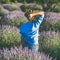 Young woman in straw hat enjoying lavender field, square crop