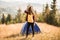 Young woman in straw hat meets autumn morning in touristic camping tent.