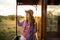 Young woman in straw hat traveling by retro wooden train.