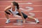 Young Woman Stretching on Running Track