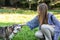 Young woman stroking a dog with grey fur. Outdoor portrait of young woman and senior dog.