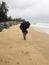 A young woman strolling on the beaches of Kundapura under an umbrella