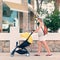 Young woman strolling pushchair with sleeping baby