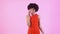 Young woman studio isolated on pink women`s day in red dress talking on phone shocked