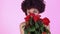 Young woman studio isolated on pink women`s day smelling roses close-up