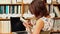 Young woman studying in library with laptop