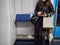 A young woman in a subway car in a protective mask holds a smartphone