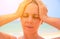 Young woman suffering with headache. Woman on hot beach with sunstroke. Health problem on holiday.