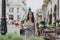 Young woman in summer dress and sandals in the city center. Woman in old town. The girl is walking