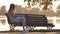 Young woman in summer dress sitting relaxed on lake side bench on warm evening. Wellness resting from everyday rush