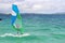 Young woman in sun protective suit windsurfing in the Caribbean