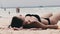 Young Woman Sunbathes on a Paradise Sandy Beach Lying in Black Bikini near Ocean