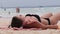 Young Woman Sunbathes on a Paradise Sandy Beach Lying in Black Bikini near Ocean