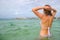 Young woman sunbathes in the sea.