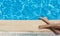 Young woman is sunbathing near a turquoise swimming pool on a sunny day