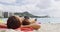 Young Woman Sunbathing On Shore At Waikiki Beach, Honolulu