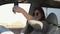 Young woman with sunglasses sits in car and takes selfie in summer morning