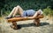 Young woman with sunhat in sailor outfit is lying on the wooden