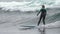 Young woman surfer athlete in wetsuit riding storm wave, surfing in splashing waves Pacific Ocean. Slow motion