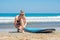 Young woman surfer getting on the surfboard`s leash