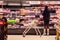 A young woman surveying meat aisle at Coles Supermarket