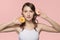 Young woman with a sweet donut in her hands. Portrait on a pink background