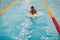 Young woman swimmer swims in swimming pool. Motion blur