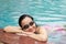 Young woman with swimming glass smiling in pool