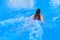 Young woman swims breaststroke in blue pool