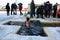 Young woman swims in the cross shaped ice hole during the Epiphany
