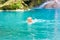 Young woman swims in emerald blue lake, Erawan National park, Thailand