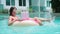 Young woman swims in the sea in a swimming circle. Girl resting in the pool on an inflatable circle with a computer, top