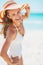 Young woman in swimsuit and beach hat at seaside