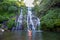 Young woman in swimsuit in front of Banyumala twin waterfalls on Bali