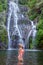 Young woman in swimsuit in front of Banyumala twin waterfalls on Bali