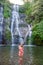 Young woman in swimsuit in front of Banyumala twin waterfalls on Bali