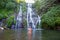 Young woman in swimsuit in front of Banyumala twin waterfalls on Bali