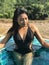 Young woman in swimsuit standing in blue pool.