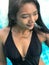 Young woman in swimsuit standing in blue pool.