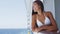 Young woman in swimsuit standing on cruise ship at sunny day looking at sea