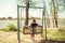 Young woman swinging on a swing. Girl sitting on a swing