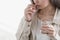 Young woman take pill, holding glass of water