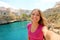 Young woman take selfie in her summer holidays in Polignano a mare, Mediterranean Sea, Apulia, Italy