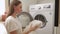 Young woman takes clean white underwear out of the washing machine. A woman enjoys the smell of fresh underwear