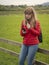 Young woman takes a phone call while standing in a typical Irish scenery