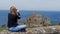 Young woman takes photos of Dunluce Castle in North Ireland