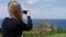 Young woman takes photos of Dunluce Castle in North Ireland