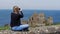 Young woman takes photos of Dunluce Castle in North Ireland