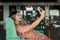 A young woman takes a selfie on her phone and sits at a table in a beautiful cafe. Side view