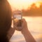 Young Woman Takes Smart Phone Photo at Sunset on Beach